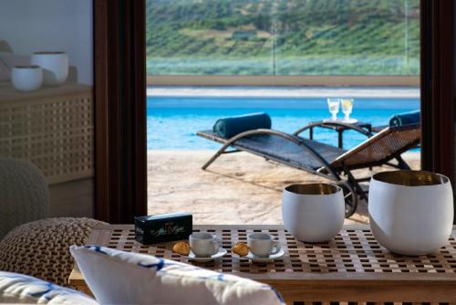 a table with a view of the ocean from a hotel room at Stylish Villa Liatiko - Heated pool - Amazing views in Epáno Váthia