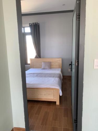 a bedroom with a bed and a window at Nomad Stay in Phan Rang