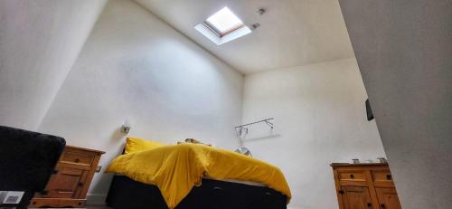 a bedroom with a yellow pillow on a bed at Deepcut Lodge Bed & Breakfast Self Service in Camberley