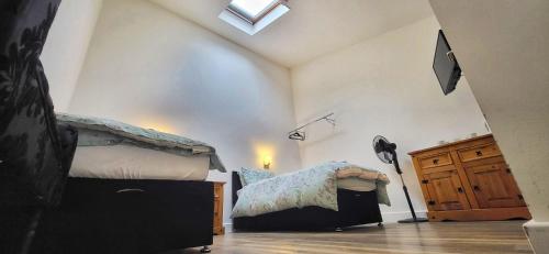 a bedroom with two twin beds and a window at Deepcut Lodge Bed & Breakfast Self Service in Camberley
