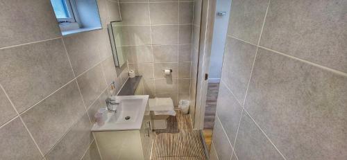 a bathroom with a sink and a shower at Deepcut Lodge Bed & Breakfast Self Service in Camberley