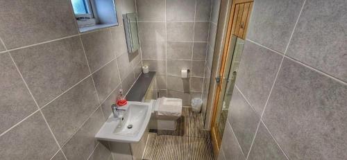 a bathroom with a sink and a shower at Deepcut Lodge Bed & Breakfast Self Service in Camberley