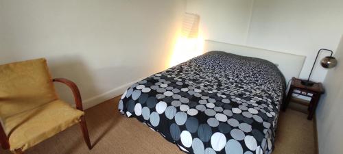 a small bedroom with a bed and a chair at Le nid d'Eugénie in Blaudeix