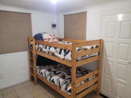 a wooden bunk bed in a room with towels at Tally-Grey Cottage in Albert Falls