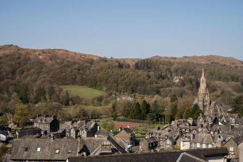 a town with houses and a church and a mountain at Barnes Fell Apartments in Ambleside