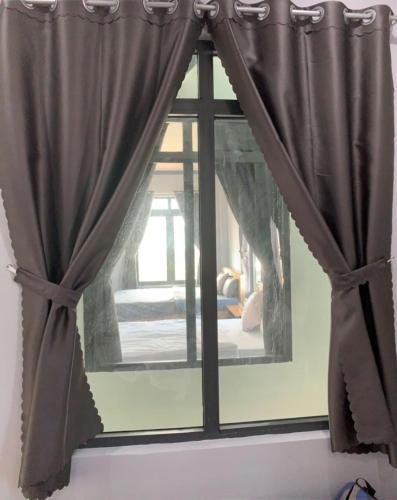 a mirror in a room with a window at Nomad Stay in Phan Rang