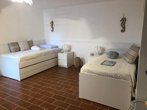 a bedroom with two beds and a tiled floor at TOBY HOUSE in Calasetta