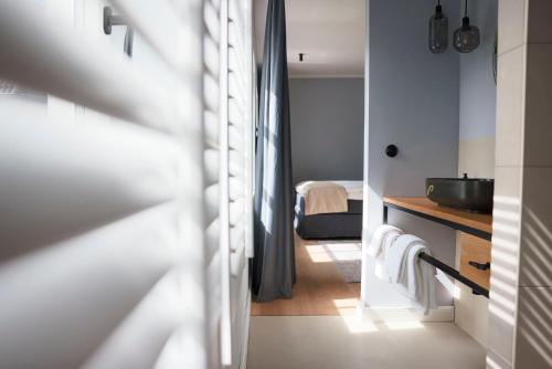 um quarto com uma casa de banho com um lavatório e uma cama em Boutiquehotel Petuh em Flensburg