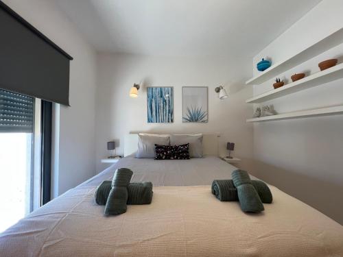 a bedroom with a large bed with two pillows at Casa Parreira Raposeira, Algarve in Raposeira