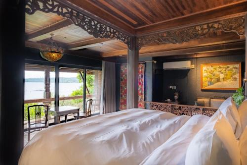 a bedroom with a large bed and a balcony at Nuuk Taal Lake in Laurel