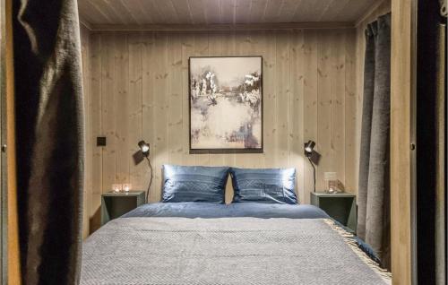 a bedroom with a bed with blue pillows at Amazing Home In Lillehammer With 5 Bedrooms, Sauna And Wifi in Lillehammer