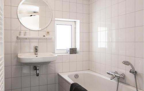 een witte badkamer met een wastafel, een bad en een spiegel bij Dampol in Ommen