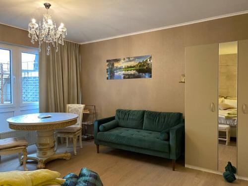 ein Wohnzimmer mit einem grünen Sofa und einem Tisch in der Unterkunft Studio Montaigne in Lüttich