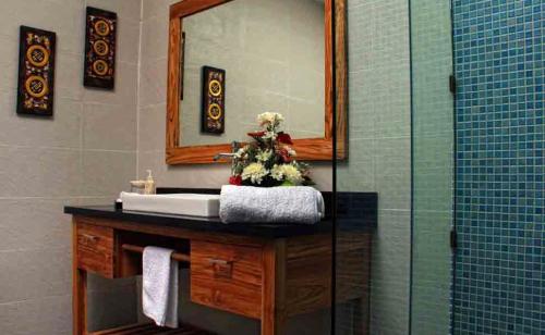 a bathroom with a sink and a mirror at Villa DiKebun in Uluwatu