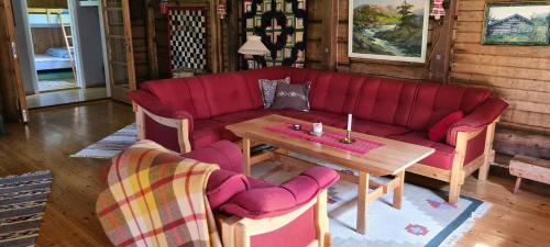 a living room with a red couch and a wooden table at Villa Fregn in Ljørdal