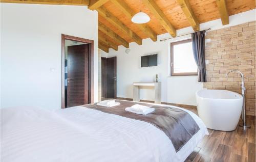 a bedroom with a large bed and a bath tub at Awesome Home In Bibici With Jacuzzi, Sauna And Wifi in Bibići