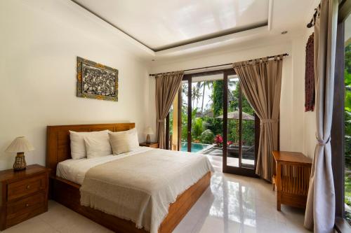 1 dormitorio con 1 cama y puerta corredera de cristal en Kubu Bali Baik Villa & Resort - CHSE Certified, en Ubud