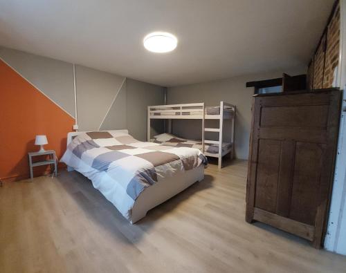 a bedroom with a bed and a wooden floor at La Rustique in Dinant