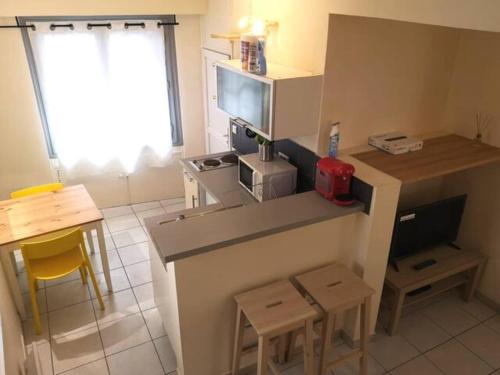 a kitchen with a counter with a microwave and a table at T2 - Coeur d'Ecusson in Montpellier