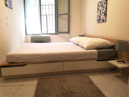 um quarto com uma cama, uma janela e um tapete em T2 - Coeur d'Ecusson em Montpellier