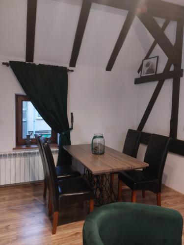 Apartament Krawcownia في شفييدبودجين: غرفة طعام مع طاولة وكراسي خشبية