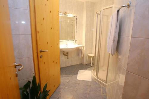 La salle de bains est pourvue d'une douche et d'un lavabo. dans l'établissement Pension Buch, Bed and Breakfast, à Eberau