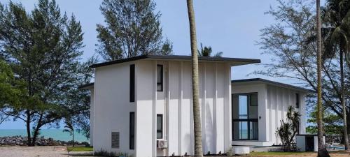 een wit huis met een palmboom ervoor bij Meet Up Villa 