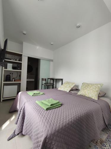 1 dormitorio con 1 cama morada y 2 toallas en Room near the sea, en Marbella