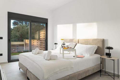 een slaapkamer met een groot wit bed en een tafel. bij Maison Du Jardin 2-Bedroom Apartment Private Outdoor Jacuzzi in Rhodos-stad