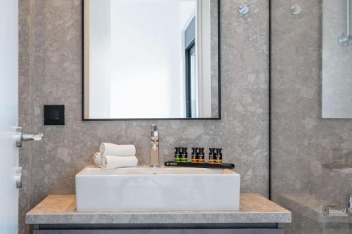 een badkamer met een witte wastafel en een spiegel bij Maison Du Jardin 2-Bedroom Apartment Private Outdoor Jacuzzi in Rhodos-stad