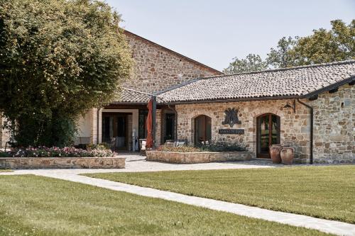 a stone house with a garden and a yard at Borgo Lanciano in Castelraimondo