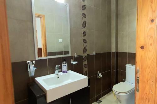 y baño con lavabo, aseo y espejo. en Bodrum Gundogan Full Sea View With Garden Triplex Villa en Bodrum