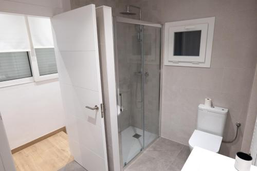 a bathroom with a shower with a toilet and a window at Niu del Sol in Vic