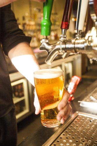 a person is holding a glass of beer at Central Hotel Hobart in Hobart