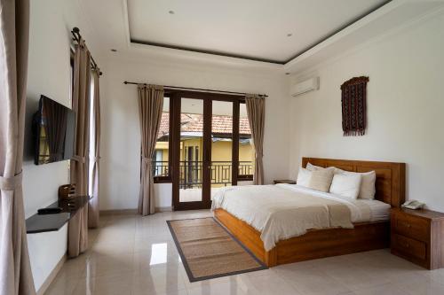 a bedroom with a bed and a television in it at Kubu Bali Baik Villa & Resort - CHSE Certified in Ubud