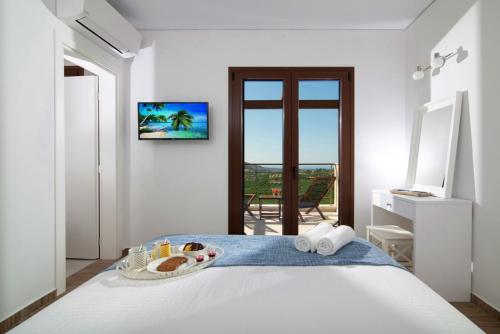 a bedroom with a bed with a tray of food on it at Luxury Villa Malvasia with Seaview and Heated pool in Epáno Váthia