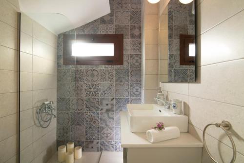 a bathroom with a sink and a mirror at Luxury Villa Malvasia with Seaview and Heated pool in Epáno Váthia