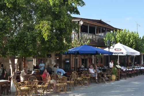 a group of people sitting at an outdoor restaurant at Luxury Villa Malvasia with Seaview and Heated pool in Epáno Váthia