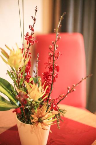 a white vase filled with flowers on a table at Central Hotel Hobart in Hobart