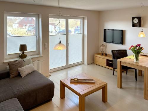 a living room with a couch and a table at Ferienwohnung *Haus Ose* in Wittdün