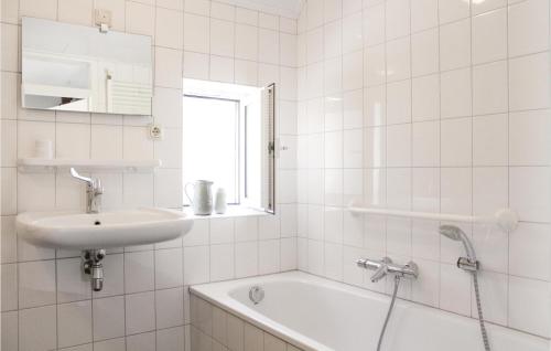 een witte badkamer met een wastafel en een bad bij Dopheide in Ommen