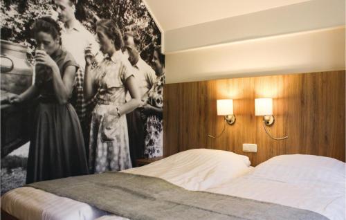 a bedroom with a bed and a picture of men and women at Dopheide in Ommen