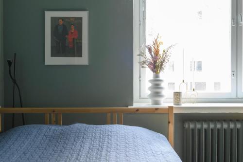 um quarto com uma cama e uma fotografia na parede em Hip studio near Central Park and City Center em Helsinque