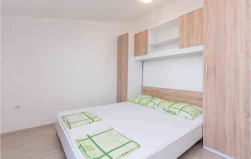 Schlafzimmer mit einem weißen Bett und Holzschränken in der Unterkunft Awesome Apartment In Biograd Na Moru With Kitchen in Biograd na Moru