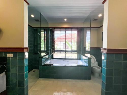 La grande salle de bains est pourvue d'une baignoire et de toilettes. dans l'établissement 3-4BR Laguna Phuket Golf Course Villa with Pool & Jacuzzi, à Laguna Phuket