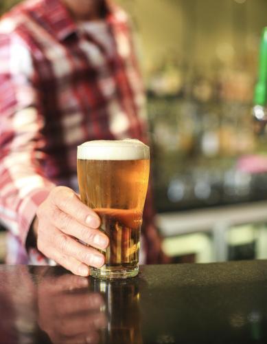 a man is holding a glass of beer at Central Hotel Hobart in Hobart