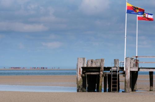 a wooden pier with a flag and a flag at Gasthaus Knudsen in Utersum