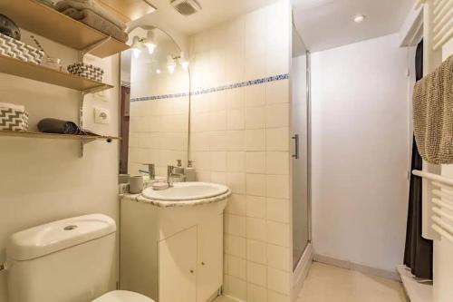 a white bathroom with a toilet and a sink at Le Gambetta - nouveau propriétaire in Estissac