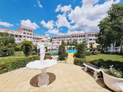 a building with a fountain in the middle of a courtyard at Fantastic Apartment in Sveti Vlas in Sveti Vlas