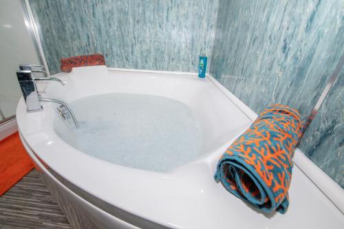 a bath tub filled with water in a bathroom at EmmaDale Bridington Town Centre Sleeps 10 in Bridlington